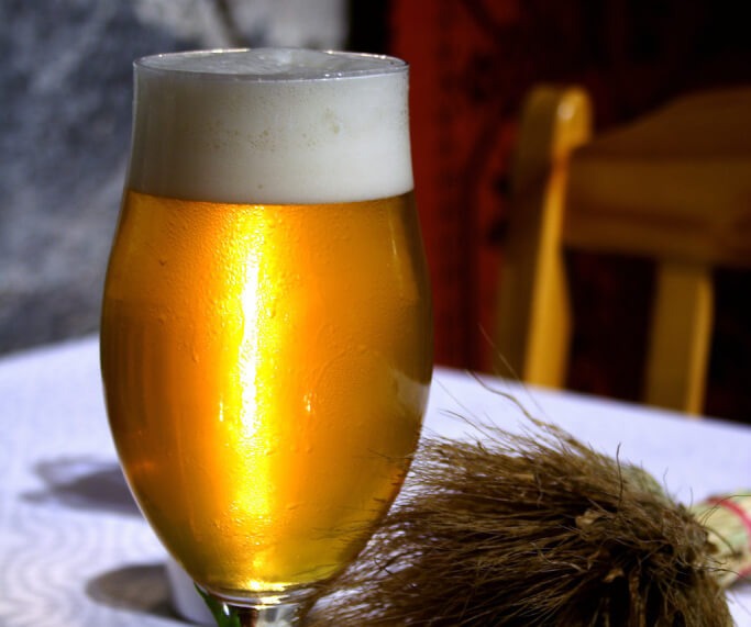 A pint of beer on a table.