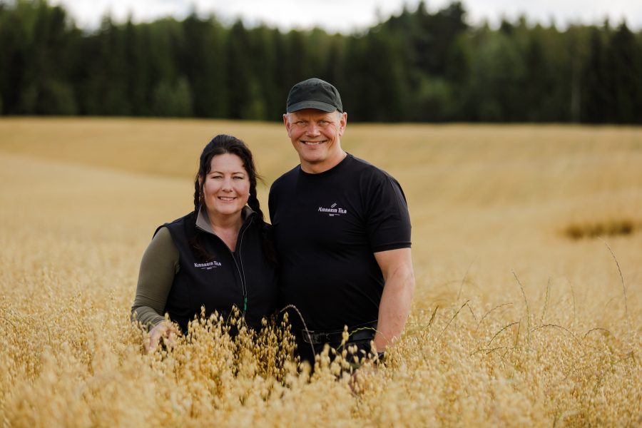 The owners of Kinnarin Tila standing on the field of oat.